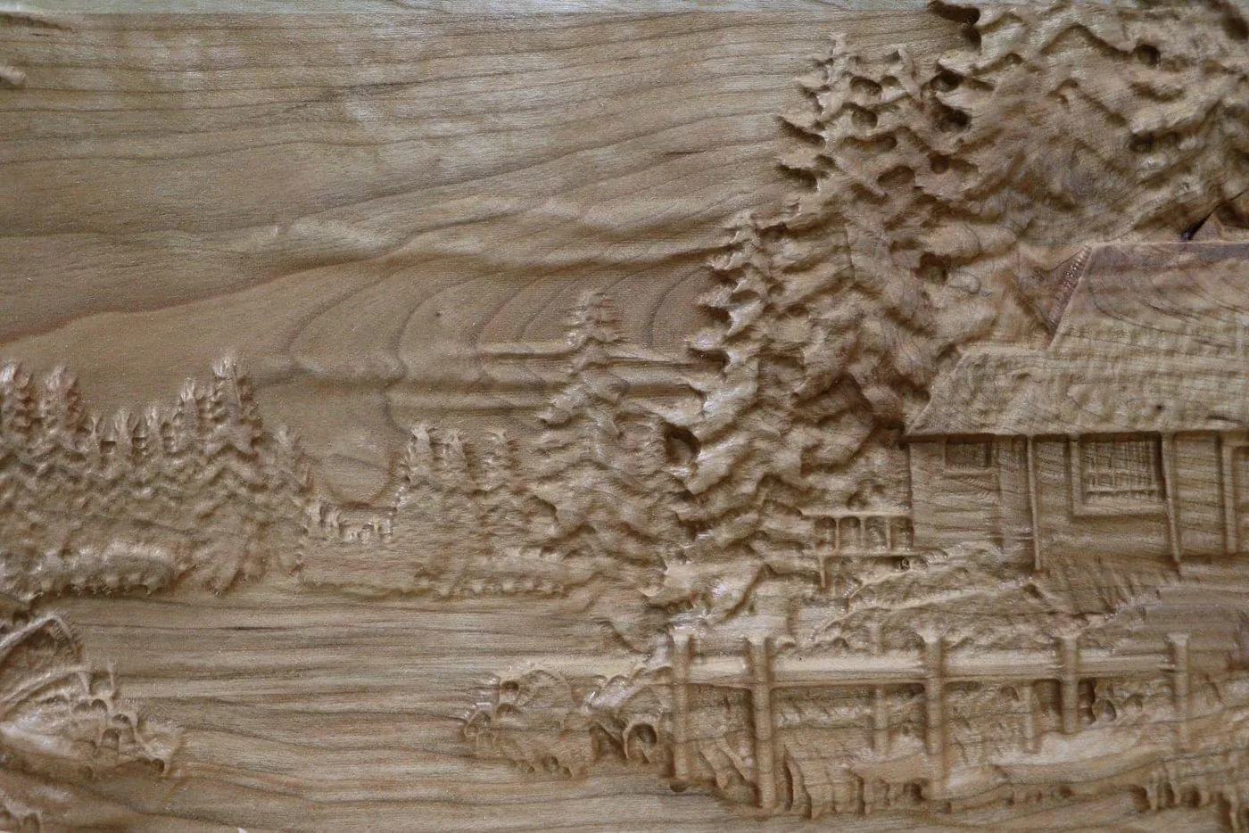 Cabin and landscape carved in layered relief